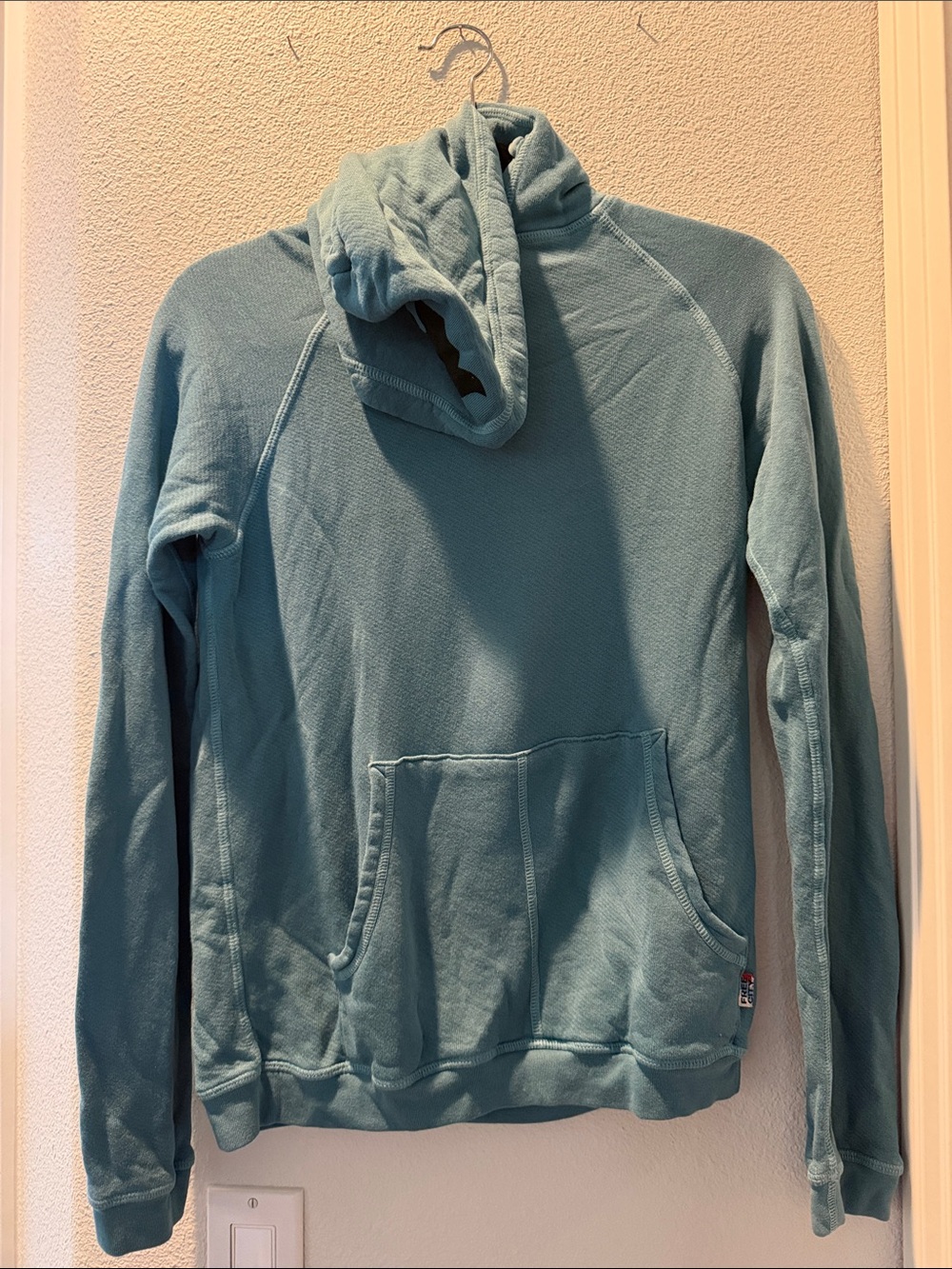 freecity muted teal sweatshirt with red logo tab